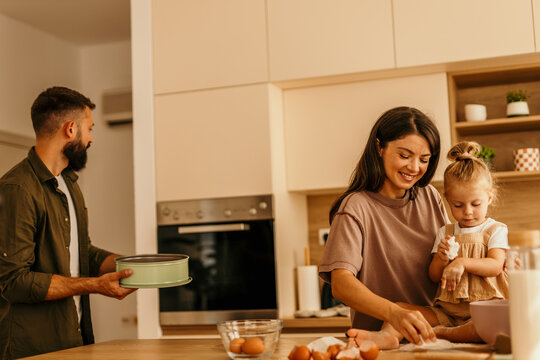Family baking together in kitchen with happy child