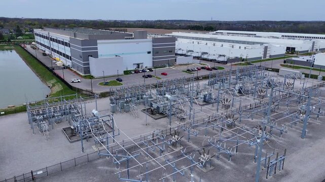 Amazon Web Services (AWS) data center for machine learning and cloud computing with power grid in aerial view