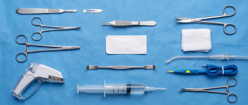 Sterile surgical instruments and supplies laid out on blue draped surgical tray for operation