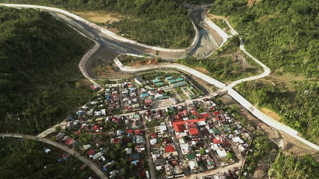 Panoramic aerial view of countryside village, winding river, and lush tropical hills - Barangay Obi, Caramoran, Catanduanes, Philippines