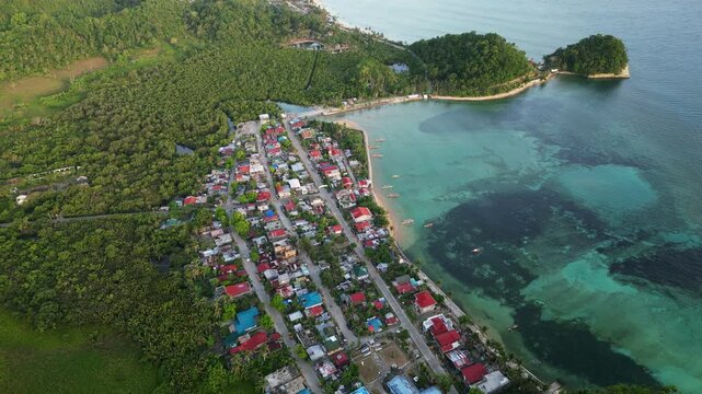 Scenic aerial view of Magnesia Del Norte in Virac, Catanduanes, showing a peaceful coastal barangay, shallow reefs, and lush tropical island greenery