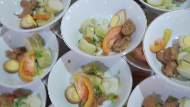 An array of gourmet multi course dishes being finalized on a plating pass line