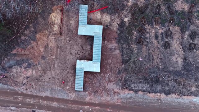 Construction of a modern zigzag staircase in a raw landscape in Top down drone footage