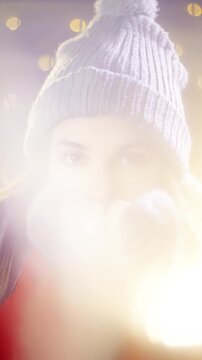 Girl with a cute look freezing outside for Christmas warming her hands