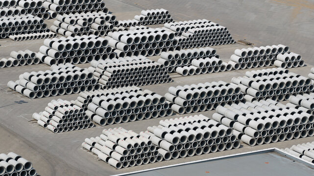 Aerial view of neatly stacked concrete pipes in an industrial storage yard under bright daylight Oosterhout, North Brabant, Netherlands.