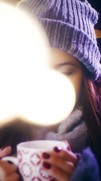 Young woman hold a cup of warm drink surrounded by Christmas spirit