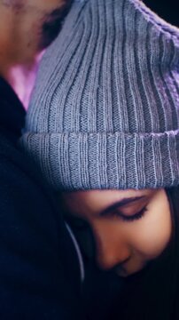 Beautiful young woman in warm hug with man leaning on chest for Christmas