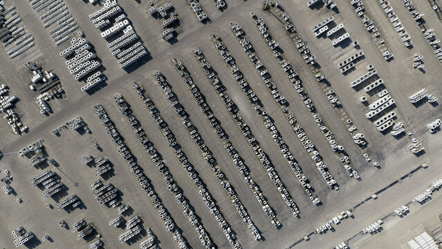 Aerial view of rows of concrete blocks and building materials arranged in an industrial storage yard under bright daylight in Oosterhout, North Brabant, Netherlands.
