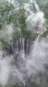 Aerial Drone View of Tumpak Sewu Waterfall Covered by Thin Clouds in East Java Indonesia