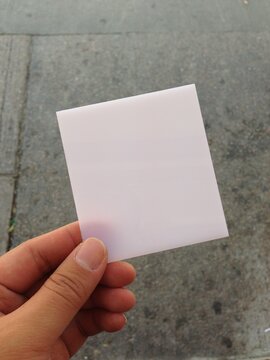 Hand Holding Blank Card Above Street