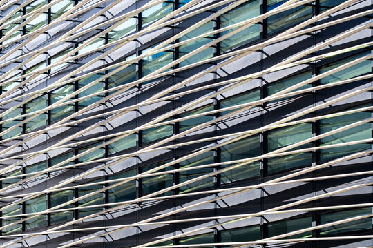 Glass facade architecture forms a geometric pattern across an urban building, where diagonal lines and windows create layered commercial rhythm.