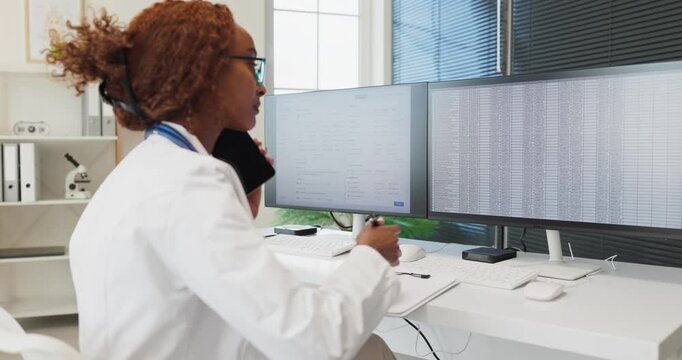 Doctor uses tablet and computer reviewing clinic records. Dual monitors display data for analysis as the workstation enables healthcare documentation. Clear concept of digital healthcare.