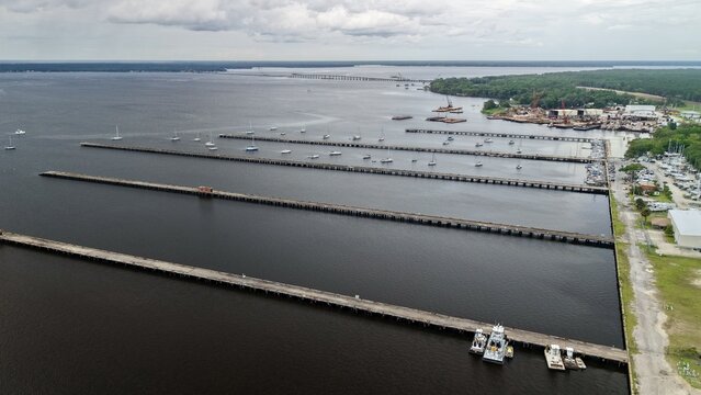 Aerial view of the long parallel piers and sailboats at the marina on the St. Johns River under a cloudy sky in Green Cove Springs, Florida, United States.