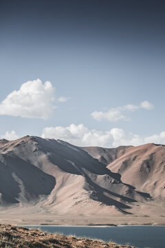 Rocky mountain slopes in the Pamir Mountains in Tajikistan, a minimalist landscape and rocky hills in sunny weather