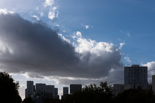 Storm clouds gather over a Paris France skyline, where dramatic sky and changing weather darken urban buildings across the distant horizon line.