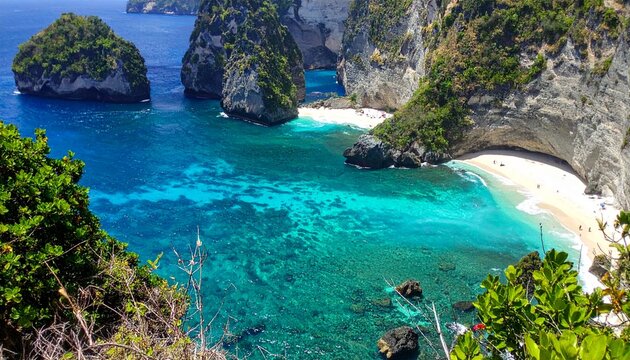 A stunning tropical lagoon surrounded by cliffs, emerald water, white sand, and lush vegetation