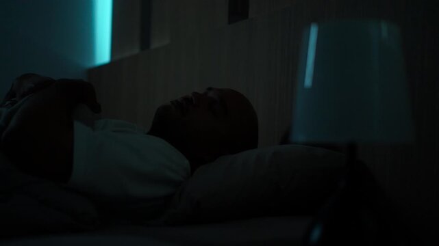 Concerned middle-aged man sleeping peacefully in comfortable bed at home. Sleep well, sweet dreams, deep sleep, relaxation, healthy lifestyle, wellness and bedtime comfort concept.
