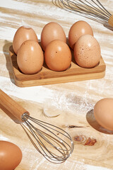 Natural Brown Eggs in Rustic Bamboo Wooden Egg Holder for Home Baking Breakfast Preparation Farm Fresh Ingredients and Sustainable Kitchen Traditions © Irina Lopik