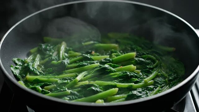 Fresh, steaming greens being saut?ed in a pan on a stovetop, capturing a cooking process