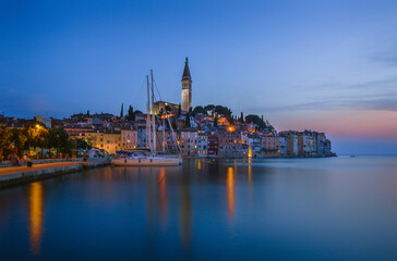 Obraz premium Rovinj Croatia Coastal Town at Dusk with Church Tower and Sailboat