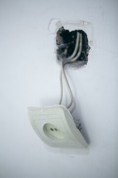 Electrical outlet on a white wall, closeup of photo.