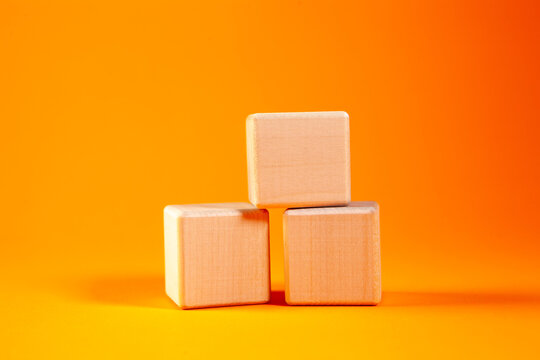 Wooden cubes isolated on orange background. Business and finance concept.