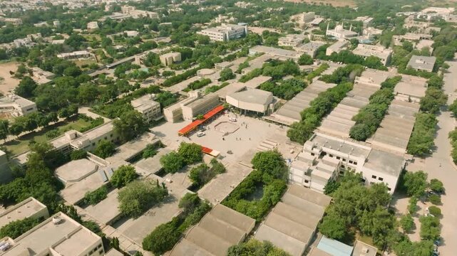 Drone shot pulling back above NED University campus surrounded by greenery in Karachi Pakistan.