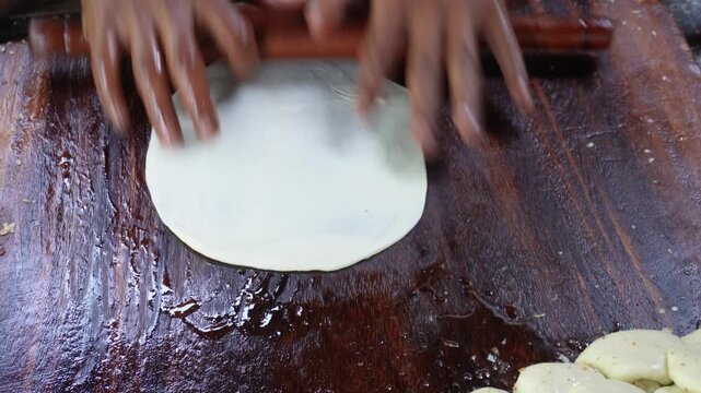 Person skillfully making traditional indian paratha flatbreads