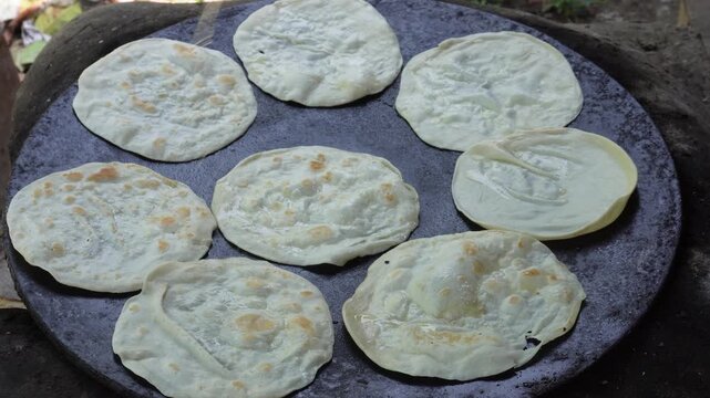 Hand cooking fresh chapatis on tawa