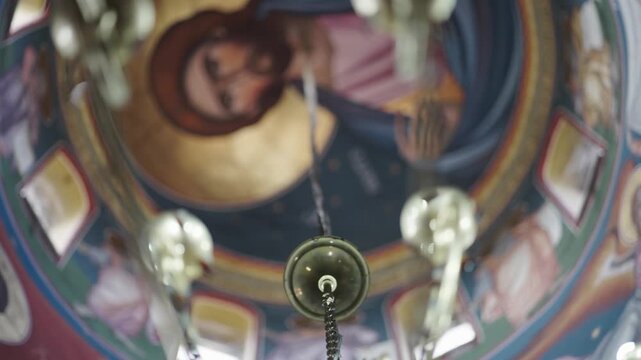 Church ceiling with Jesus religious painting and chandelier decorations in soft focus