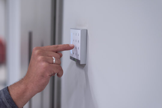 Close-up of Hand Entering PIN Code on Digital Security Keypad
