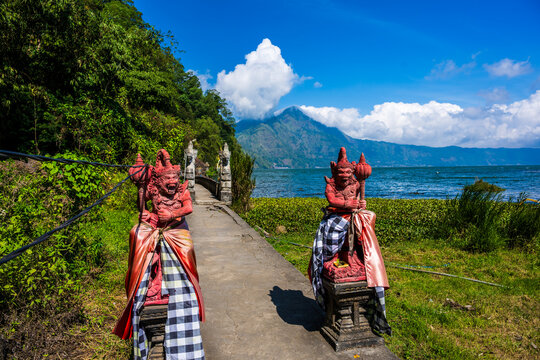 Balinese guardian statues overlooking Lake Batur and Mount Abang in Kintamani