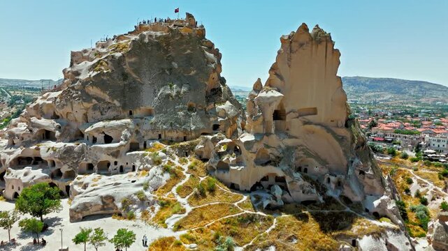 Drone view of Uchisar, Cappadocia, Turkey rock formations. Tall fairy chimneys and cave rocks stand above the town landscape.