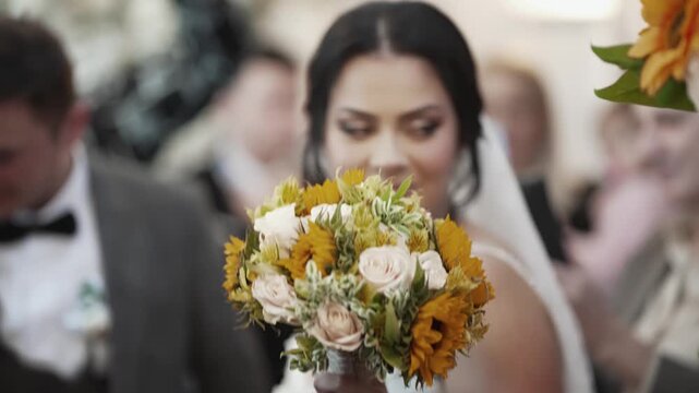 Dancing bride holding a yellow and white floral bouquet jumping during a wedding ceremony