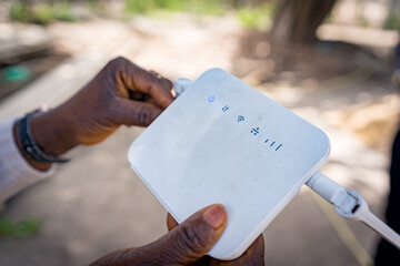 Internet router seen in black african person hands, concept of connectivity and web infrastructure in africa © davide bonaldo