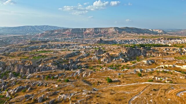 Aerial view of Rose Valley, Cappadocia, Turkey wide landscape. Dry valleys, distant mountains and carved rock formations fill the panorama.