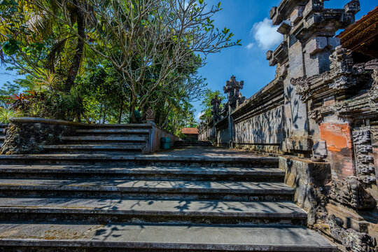 Stone stairs and ornate wall at Pura Dalem Ubud with tropical trees