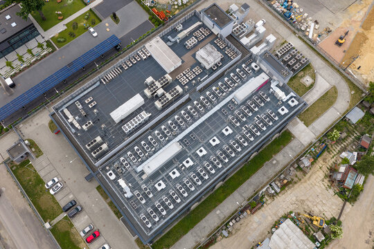 Aerial view of AI data center featuring numerous cooling units and HVAC systems on the roof with a parking lot Warszawa, Wojewodztwo mazowieckie, Poland.