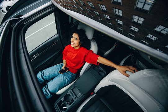 Woman passenger in car using smartphone during relaxed city travel