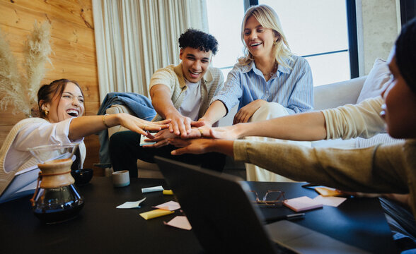 Young professionals collaborating with enthusiasm in a modern coworking space