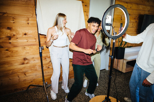 Group of friends creating content with a phone and light ring setup