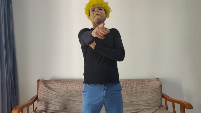 Person in funny mask pointing finger