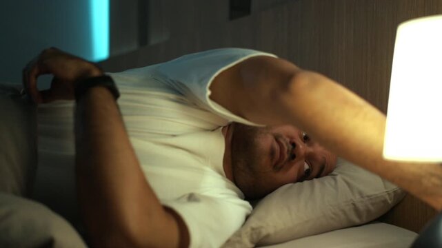 Man sleeping peacefully while wearing a smart watch for sleep tracking. Deep sleep monitoring wearable technology, Recovery wellness, healthy lifestyle and longevity concept.
