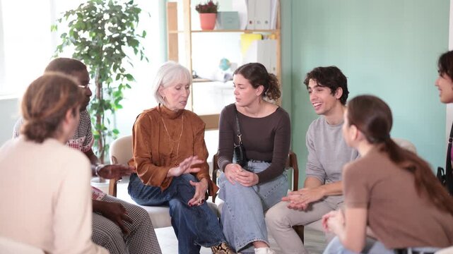 People sit in the interior in the office in a circle and talk about psychology. Men and women in a psychological support group