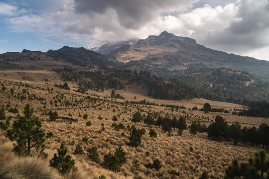 Scenic view of Popocat&eacute;petl volcano in Mexico with cloudy sky and lush vegetation during daytime ideal for travel and adventure enthusiasts