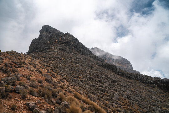 Rugged rocky landscape of Popocat&eacute;petl volcano in Mexico under cloudy sky ideal for hiking and trekking adventures