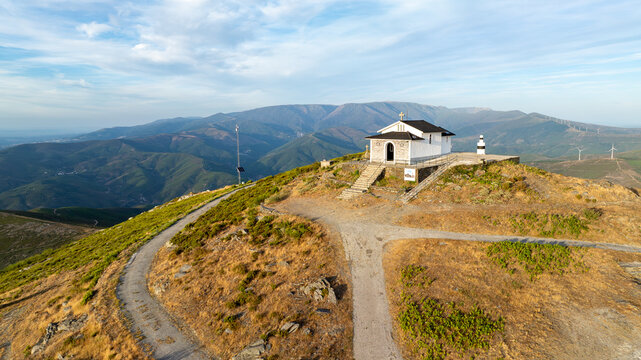 Aerial view of Capela da Senhora das Necessidades do Monte do Colcurinho on a mountain peak with winding paths and wind turbines Aldeia das Dez, Coimbra, Portugal.