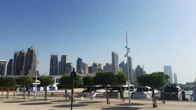 Panoramic view of Dubai Marina with luxury yachts pier and tall city skyscrapers