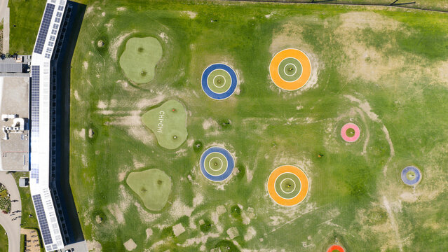 Aerial view of Chi Chi - The Golf Venue featuring colorful circular targets on the green grass and a building with solar panels in Utrecht, Utrecht, Netherlands.