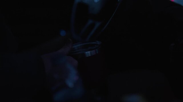 A Person Holding a Thermos Cup While Driving on a Hunting Road Trip - POV Shot